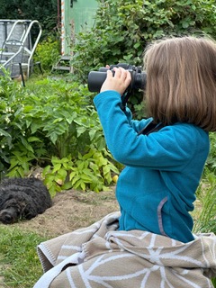Kind mit Fernglas im Garten